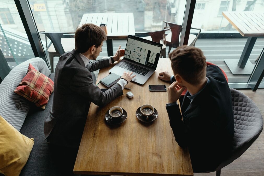 Two Young Businessman Having Successful Meeting Restaurant